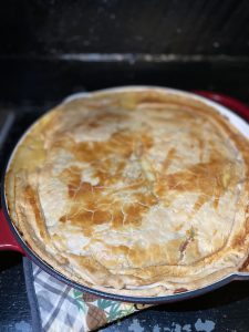 To show cheesy chicken and sausage pot pie on counter in pan.