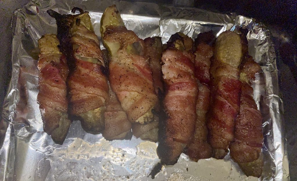 Cooked bacon wrapped pickles. 